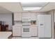 Kitchen boasts white appliances, cabinets, and a tile floor at 8405 Divot Way, Port Richey, FL 34668
