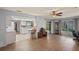 Open living area with wood floors flowing into a kitchen with white cabinets and bar seating at 8405 Divot Way, Port Richey, FL 34668