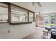 View of the sunroom's pass-through window into the kitchen and outdoor views through screened windows at 8405 Divot Way, Port Richey, FL 34668
