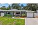 Charming single-story home featuring a well-manicured lawn and a welcoming front porch with decorative landscaping at 9000 Bay Ne St, St Petersburg, FL 33702