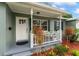 Inviting covered front porch with decorative landscaping, a white railing, and seating space perfect for relaxing at 9000 Bay Ne St, St Petersburg, FL 33702