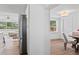 Hallway view showing stainless steel refrigerator and open concept to living and dining areas at 9000 Bay Ne St, St Petersburg, FL 33702