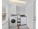Laundry room with washer, dryer, overhead storage, and a window allowing natural light at 9000 Bay Ne St, St Petersburg, FL 33702