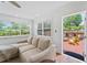 Bright living room with a comfy couch, large windows, and access to the deck and backyard at 9000 Bay Ne St, St Petersburg, FL 33702