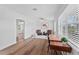 Bright living room featuring hardwood floors, ceiling fan, and neutral paint, with large windows allowing ample natural light at 9000 Bay Ne St, St Petersburg, FL 33702