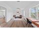 Bright living room featuring hardwood floors, ceiling fan, and neutral paint, with large windows allowing ample natural light at 9000 Bay Ne St, St Petersburg, FL 33702