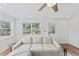 Cozy living room with a comfortable sectional sofa, ceiling fan and a view of the lush backyard at 9000 Bay Ne St, St Petersburg, FL 33702