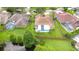 Aerial view showcasing a home with a screened-in pool, lush landscaping, and proximity to a pond at 9813 Woodbay Dr, Tampa, FL 33626