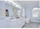 Bright bathroom with double vanity sinks, modern tub, and a large mirror at 9813 Woodbay Dr, Tampa, FL 33626