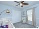 Cozy bedroom with a crib, ceiling fan, and a comfortable chair at 9813 Woodbay Dr, Tampa, FL 33626