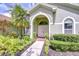 Home front entrance with arched entry way, double doors and manicured landscaping at 9813 Woodbay Dr, Tampa, FL 33626