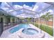 Inviting backyard with a private pool, spa, and screened enclosure at 9813 Woodbay Dr, Tampa, FL 33626