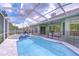 Backyard pool with screen enclosure and hot tub providing a serene oasis for relaxation and entertaining at 9813 Woodbay Dr, Tampa, FL 33626