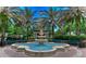 Beautiful water fountain surrounded by palm trees, benches and greenery in a park setting at 9813 Woodbay Dr, Tampa, FL 33626