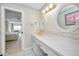Bathroom vanity with double mirrors and white countertop, with an open doorway view to the bedroom at 100 Bluff View Dr # 511C, Belleair Bluffs, FL 33770