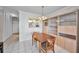 Dining room with wooden table and chairs, featuring an adjacent cabinet and a view into the kitchen area at 100 Bluff View Dr # 511C, Belleair Bluffs, FL 33770