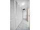 Hallway with many large white louvered closet doors and white tile flooring at 100 Bluff View Dr # 511C, Belleair Bluffs, FL 33770