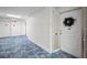 Hallway with blue carpet leading to the unit entrance, offering a welcoming and well-maintained atmosphere at 100 Bluff View Dr # 511C, Belleair Bluffs, FL 33770