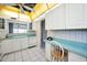 Kitchen with blue countertops, white cabinets and appliances, and a window with an outdoor view at 100 Bluff View Dr # 511C, Belleair Bluffs, FL 33770