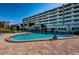Enjoy the sparkling pool with dolphin fountain and sundeck with community building at 100 Bluff View Dr # 511C, Belleair Bluffs, FL 33770