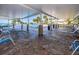 Relaxing covered patio area with brick columns, lounge chairs, and a view of the beautiful pool and waterfront at 100 Bluff View Dr # 511C, Belleair Bluffs, FL 33770