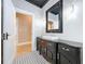 Stylish bathroom vanity with a black ornate mirror and beautiful black and white floor tiles at 1019 E Mohawk Ave, Tampa, FL 33604