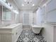 Stylish bathroom featuring a clawfoot tub, double vanity, decorative tile flooring, and a chandelier at 1019 E Mohawk Ave, Tampa, FL 33604