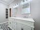 Elegant bathroom featuring a double vanity with marble countertops, patterned tile flooring and decorative mirrors and lighting at 1019 E Mohawk Ave, Tampa, FL 33604