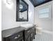 Elegant bathroom featuring a black vanity with a white vessel sink and decorative black and white tile flooring at 1019 E Mohawk Ave, Tampa, FL 33604
