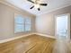 Inviting bedroom with hardwood floors, ceiling fan, natural light from windows and a doorway to the bathroom at 1019 E Mohawk Ave, Tampa, FL 33604