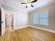 Bright bedroom with hardwood floors, white trim, ceiling fan, and natural light from double hung windows at 1019 E Mohawk Ave, Tampa, FL 33604