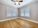 Inviting bedroom with hardwood floors, white trim, and two windows providing ample natural light at 1019 E Mohawk Ave, Tampa, FL 33604