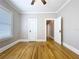 Neutral bedroom featuring original hardwood floors and white trim, with two doors and a window for natural light at 1019 E Mohawk Ave, Tampa, FL 33604
