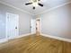 Well-lit bedroom boasting hardwood floors, white trim, ceiling fan, and three doors at 1019 E Mohawk Ave, Tampa, FL 33604