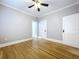 Charming bedroom featuring hardwood floors, a ceiling fan, and multiple doorways at 1019 E Mohawk Ave, Tampa, FL 33604