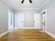 Spacious bedroom features hardwood floors, ceiling fan, and doorways to other rooms at 1019 E Mohawk Ave, Tampa, FL 33604
