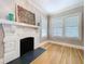 Living room showcasing a detailed fireplace, hardwood floors, and bright windows, providing a cozy atmosphere at 1019 E Mohawk Ave, Tampa, FL 33604