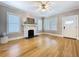 Spacious living room featuring gleaming hardwood floors, a decorative fireplace, and a modern ceiling fan for comfort at 1019 E Mohawk Ave, Tampa, FL 33604