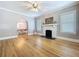 Bright living room featuring a decorative fireplace, hardwood floors, and an arched doorway to the dining area at 1019 E Mohawk Ave, Tampa, FL 33604