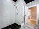 Modern bathroom with a walk-in shower, subway tile, and black accent tiles, paired with patterned flooring at 1019 E Mohawk Ave, Tampa, FL 33604