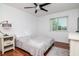 Cozy bedroom with a ceiling fan, hardwood floors, a plush rug, and natural light streaming in through the large window at 10265 Gandy N Blvd # 1702, St Petersburg, FL 33702