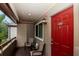 Inviting front porch with seating, a striking red door with unit number, and an exterior light fixture creating a warm welcome at 10265 Gandy N Blvd # 1702, St Petersburg, FL 33702