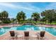 Community pool featuring waterfall, lush landscaping, and comfortable lounge chairs at 10265 Gandy N Blvd # 1702, St Petersburg, FL 33702