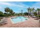 Community pool with lounge chairs, palm trees and well maintained brick border at 10265 Gandy N Blvd # 1702, St Petersburg, FL 33702