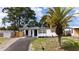 Charming home featuring a palm tree in the front yard and a newly paved driveway at 10408 118Th Ave, Largo, FL 33773