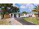 This home features a newly paved driveway and a covered front porch with chairs at 10408 118Th Ave, Largo, FL 33773