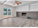 Bright living room featuring a brick fireplace, ceiling fan, and sliding doors with a pool view at 11490 48Th N Ave, St Petersburg, FL 33708
