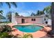 Backyard kidney pool with a concrete surround framed by tropical landscaping, ideal for outdoor living and relaxation at 11490 48Th N Ave, St Petersburg, FL 33708