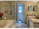 Well-lit primary bathroom features a double vanity, soaking tub, and glass enclosed shower at 11513 Andy Dr, Riverview, FL 33569