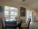 Cozy dining area with a round glass table, comfortable seating, and natural light streaming through the window at 11513 Andy Dr, Riverview, FL 33569